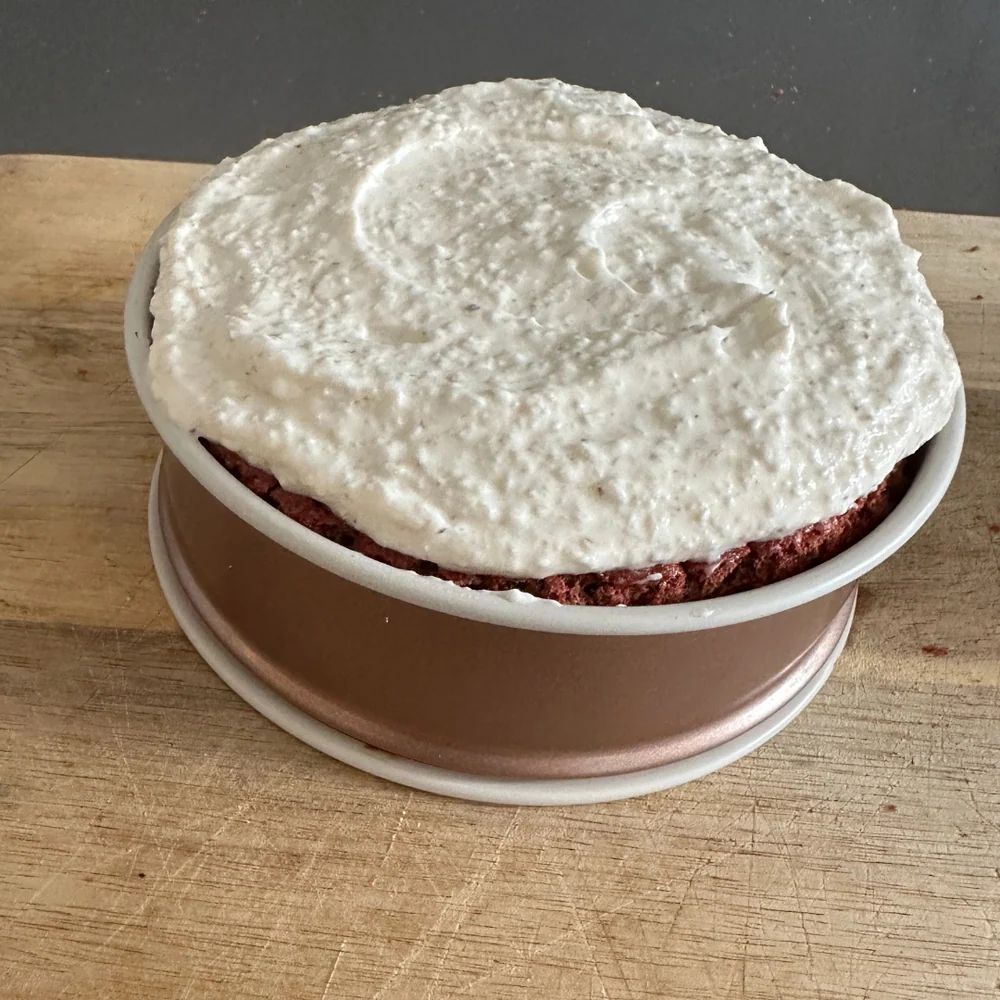 Den oberen Boden auf die Creme legen und den Rest der Creme oben auftragen.